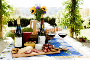 Melville Wine on charcuterie board in front of a Vineyard